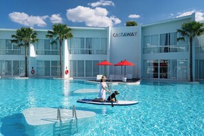 Un hôtel moderne doté d’une piscine, de palmiers et offrant une vue sur un ciel dégagé.