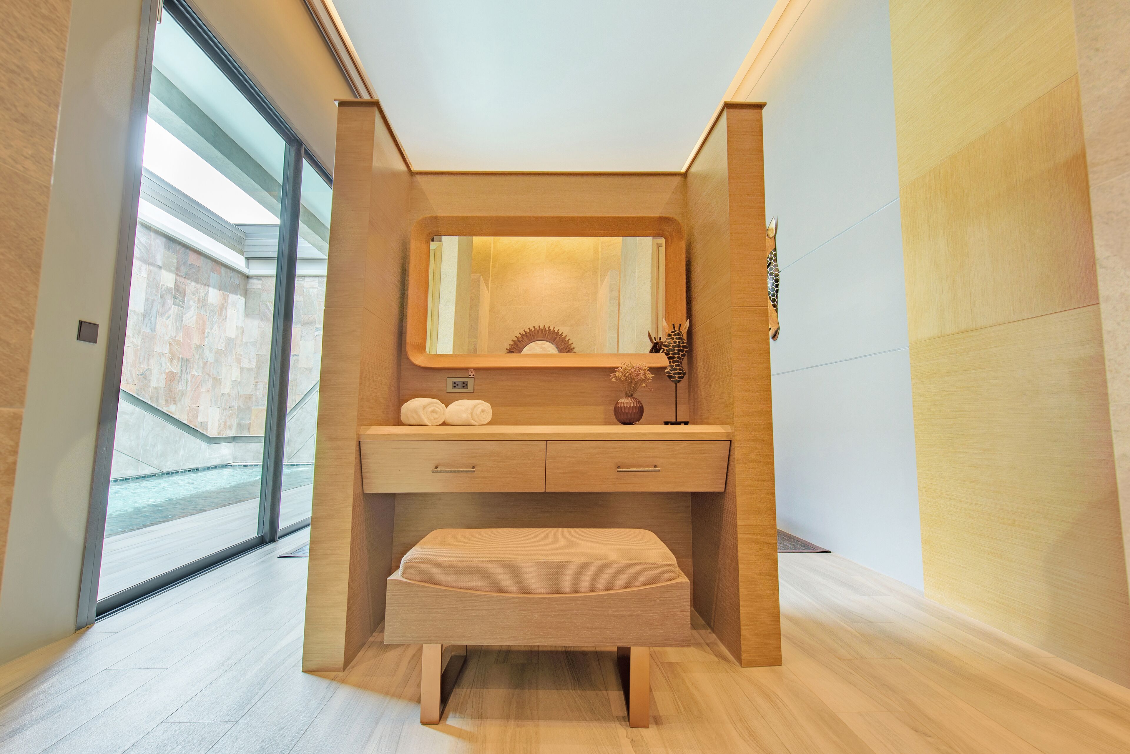 Une salle de bain moderne avec un meuble-lavabo en bois, un miroir et un banc.
