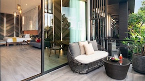 A modern living area with a sofa, a dining table, and a glass partition. - The Gems Mining Pool Villas Pattaya (Pattaya)