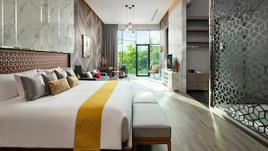 A modern hotel room with a large bed, a bench, a desk, and a view of greenery through the window. - The Gems Mining Pool Villas Pattaya (Pattaya)