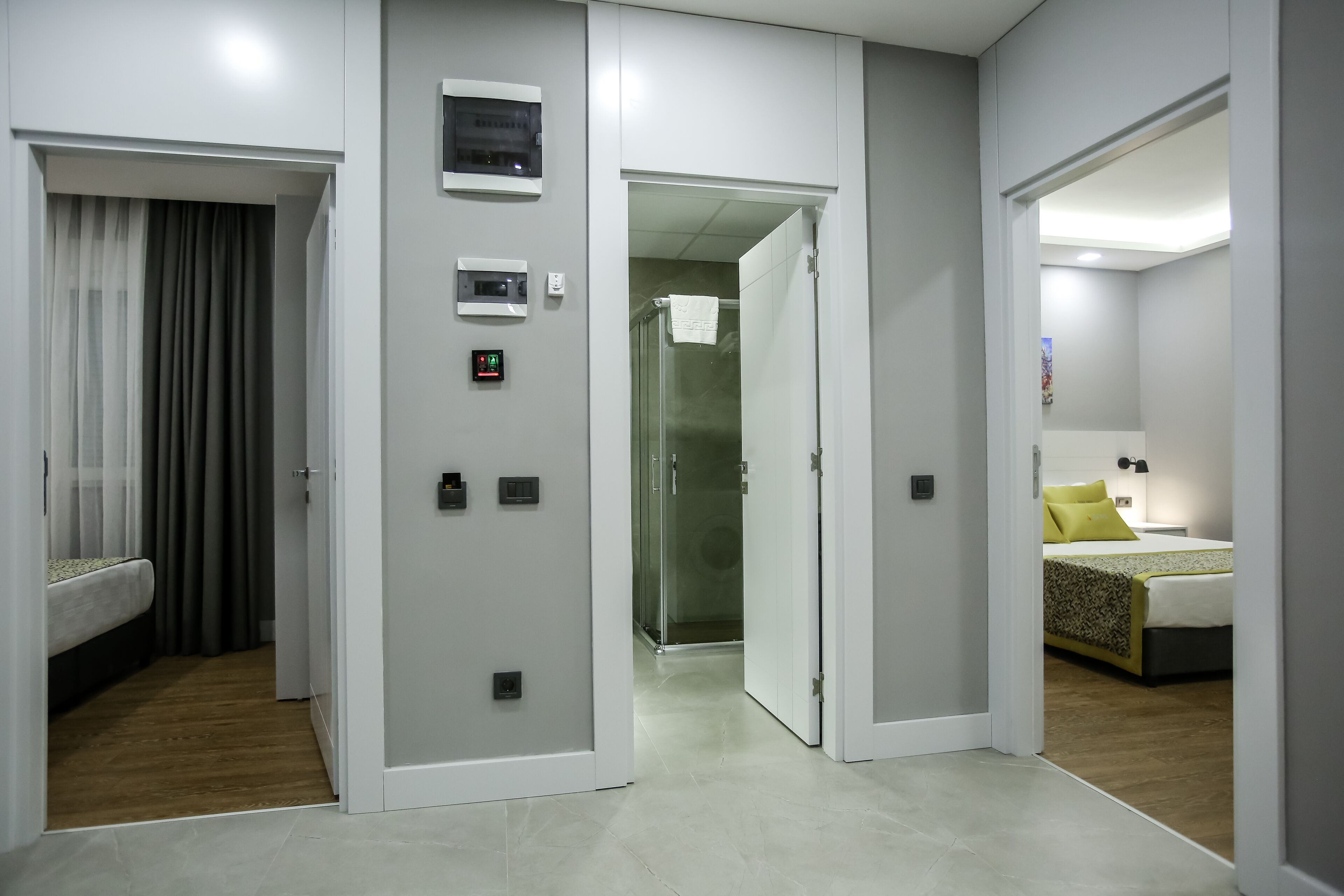 A hotel room with a bed, a bathroom with a shower, and a separate bedroom.
