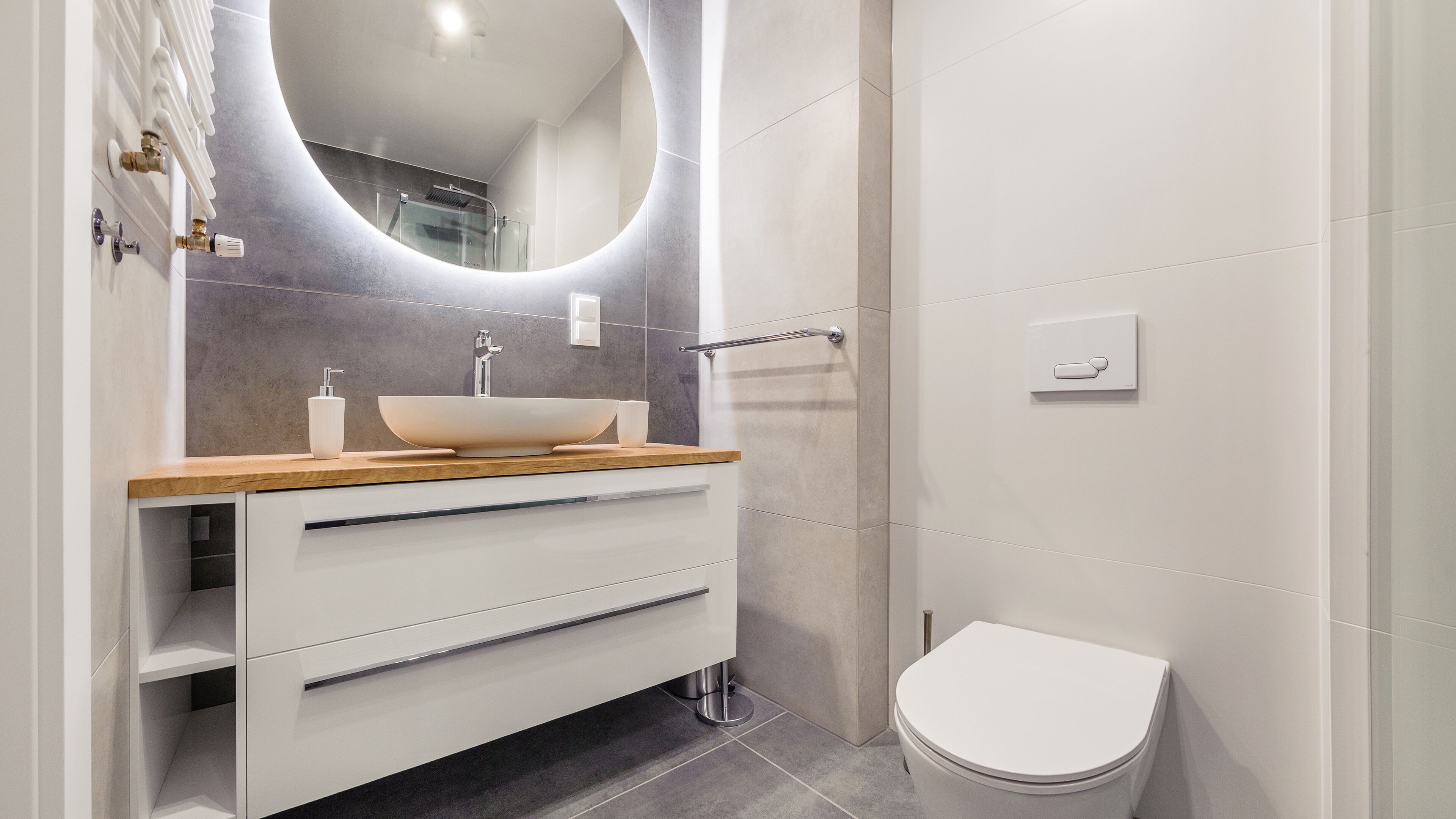 A modern bathroom with a vessel sink, a toilet, and a vanity with drawers.