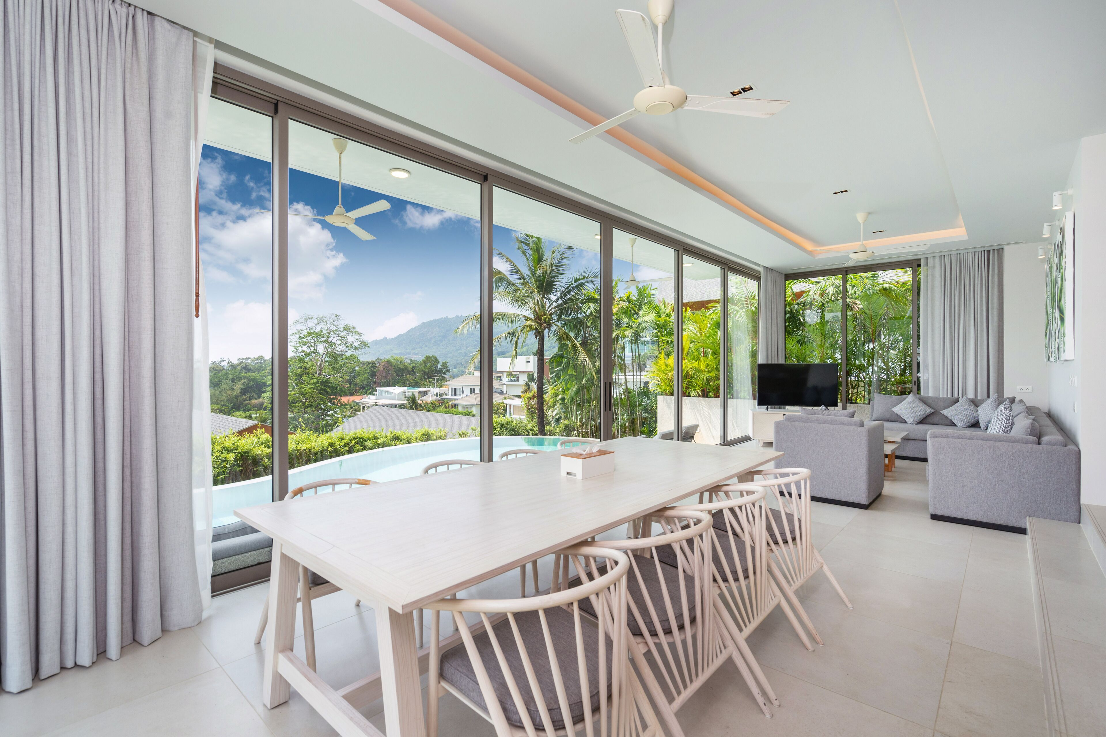 Un salón amplio con una gran mesa de comedor, un sofá y un televisor.