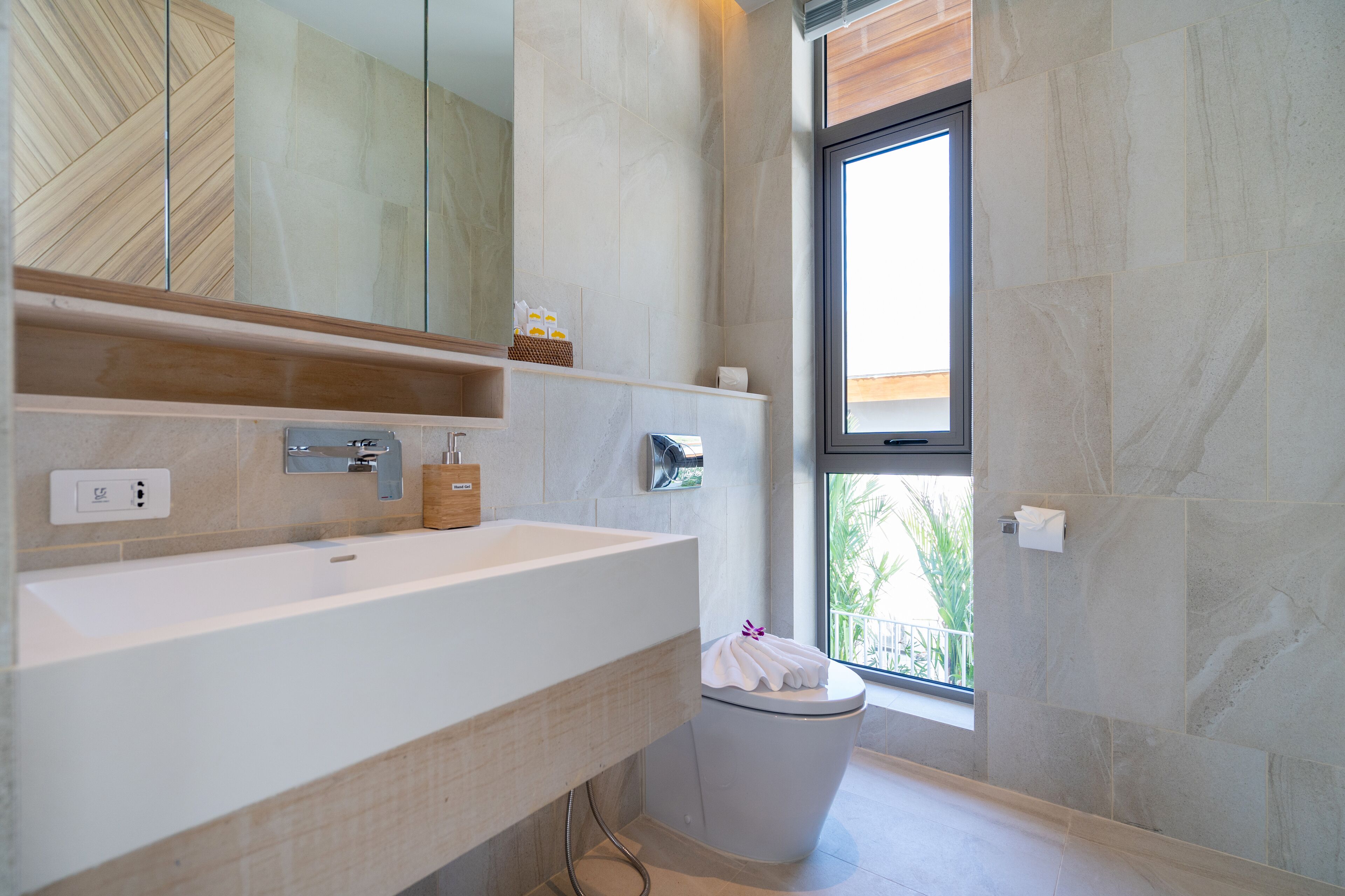 A modern bathroom with a large sink, mirror, and toilet.