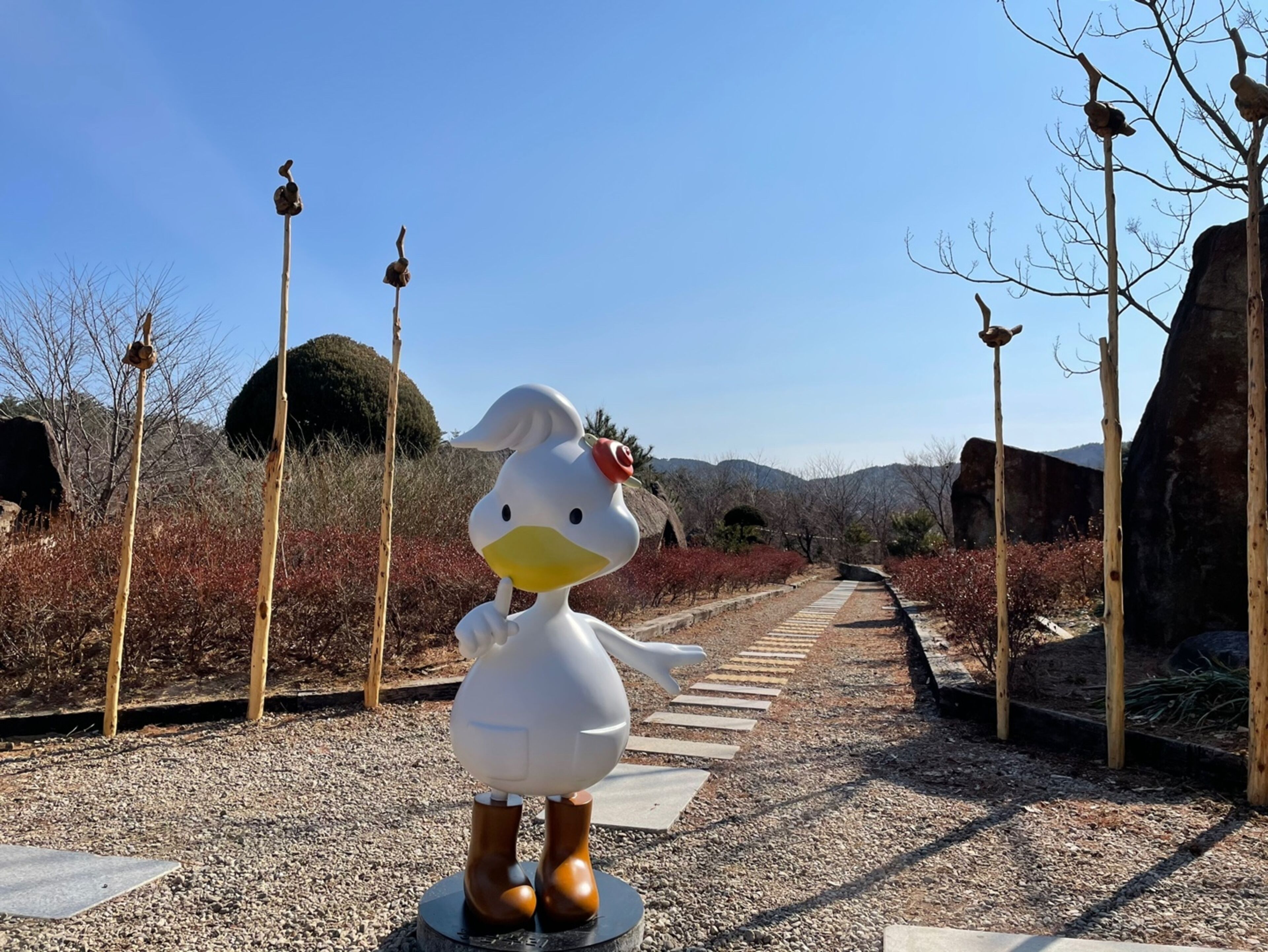 Un camino que lleva a una estatua de pato.
