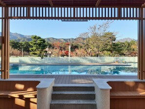 Un espace piscine offrant une vue sur les montagnes et les arbres aux couleurs automnales.