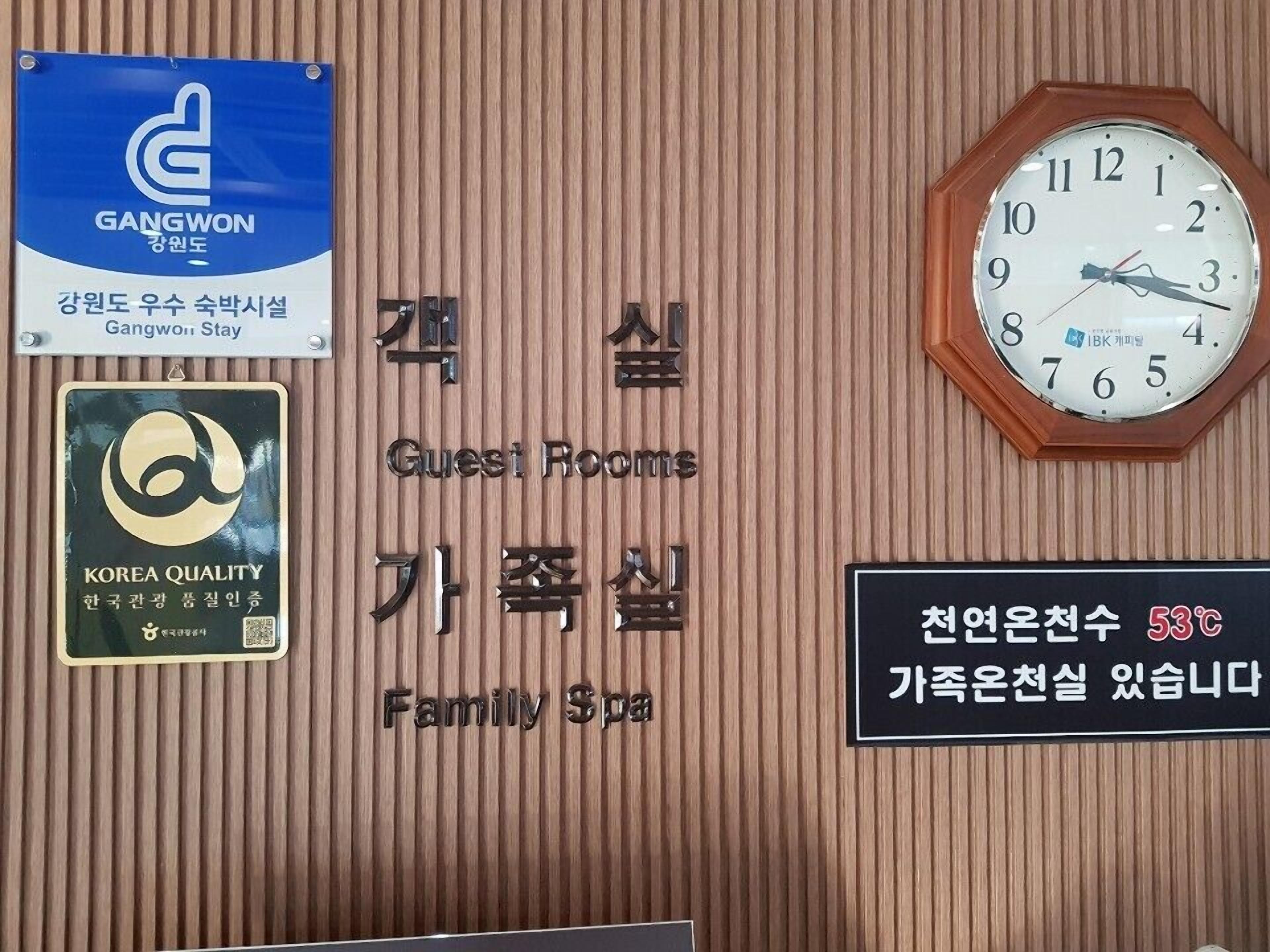 A wall with signs indicating 'Guest Rooms', 'Family Spa', and a clock.