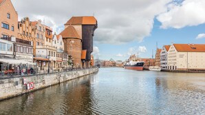 A canal with historic buildings, a prominent tower, and a museum.
