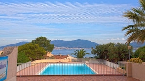 Uma piscina com vista para o mar e montanhas.