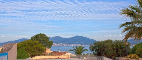 A swimming pool with a view of the sea and mountains.
