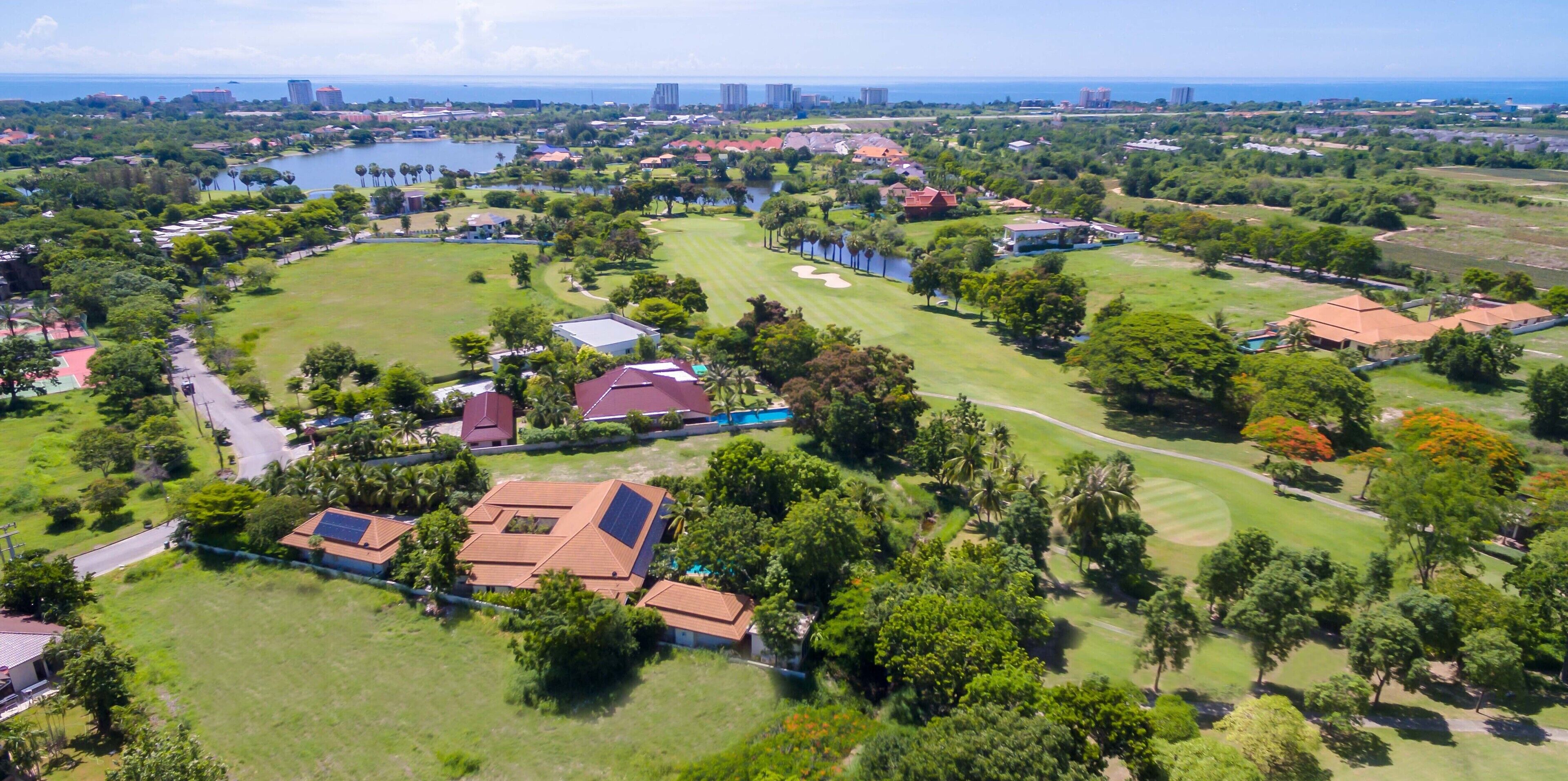 Luchtbeeld van een woongebied met huizen, een golfbaan en een waterpartij.