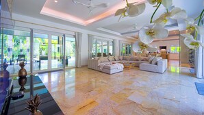 A spacious living room with a large sectional sofa, a coffee table, and a glass door leading to a balcony. - 6BR Luxury Tropical Pool Villa PH125 (Cha-am)