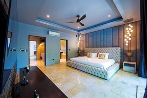 A spacious bedroom with a large bed, a ceiling fan, and a modern light fixture. - 6BR Luxury Tropical Pool Villa PH125 (Cha-am)