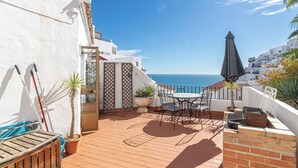 A terrace with a table and chairs, a grill, and potted plants. - Capistrano Playa 618 (Nerja)
