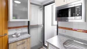 Eine moderne Küche mit eingebauter Mikrowelle, Granit-Arbeitsplatten und Holzschränken.