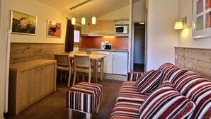 A compact living space with a kitchenette, a dining area, and a sofa. - Lovely studio cabin for 4 people, near slopes (Belle Plagne)