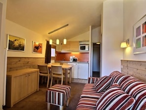 Cozy living space with a dining table, sofa, and wooden bench, perfect for relaxing and enjoying meals.