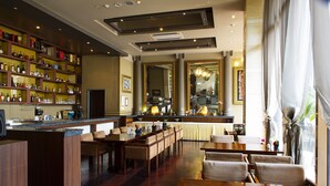A hotel lobby with a bar area, seating arrangements, and a large mirror. - Ritz Plaza Hotel (Gunsan)