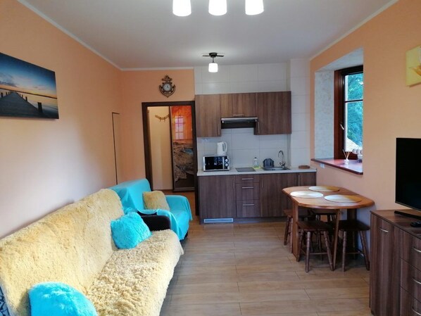 Una sala de estar acogedora con un sofá y un comedor.