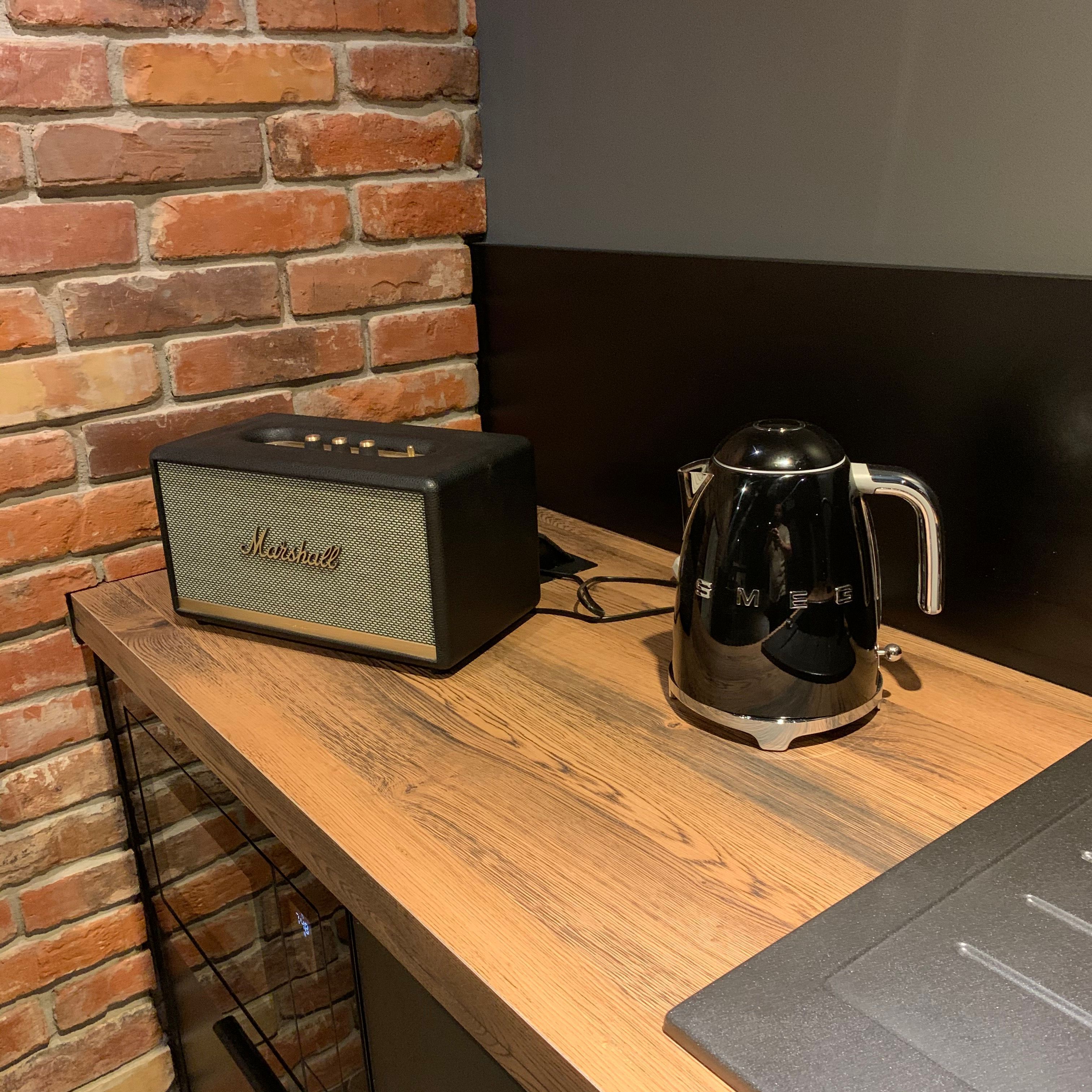 Ein Holztisch mit einem Marshall-Verstärker und einer schwarzen Kaffeemaschine.