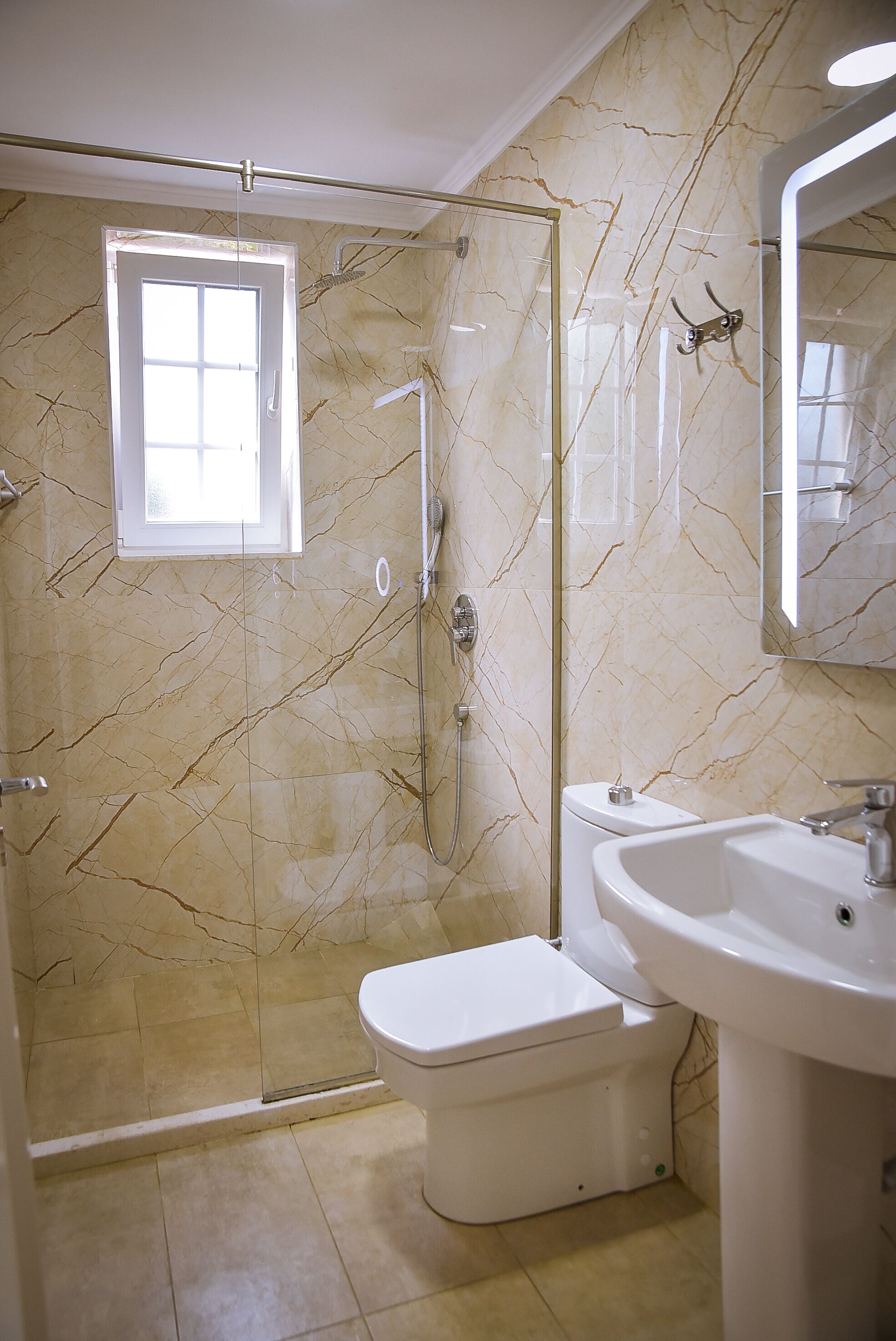 Un baño con ducha de vidrio, inodoro y lavamanos.