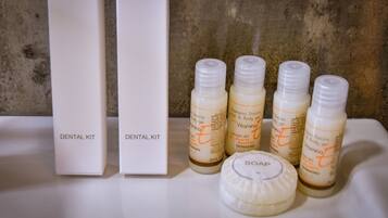 A dental kit with four bottles and a soap bar on a white surface.