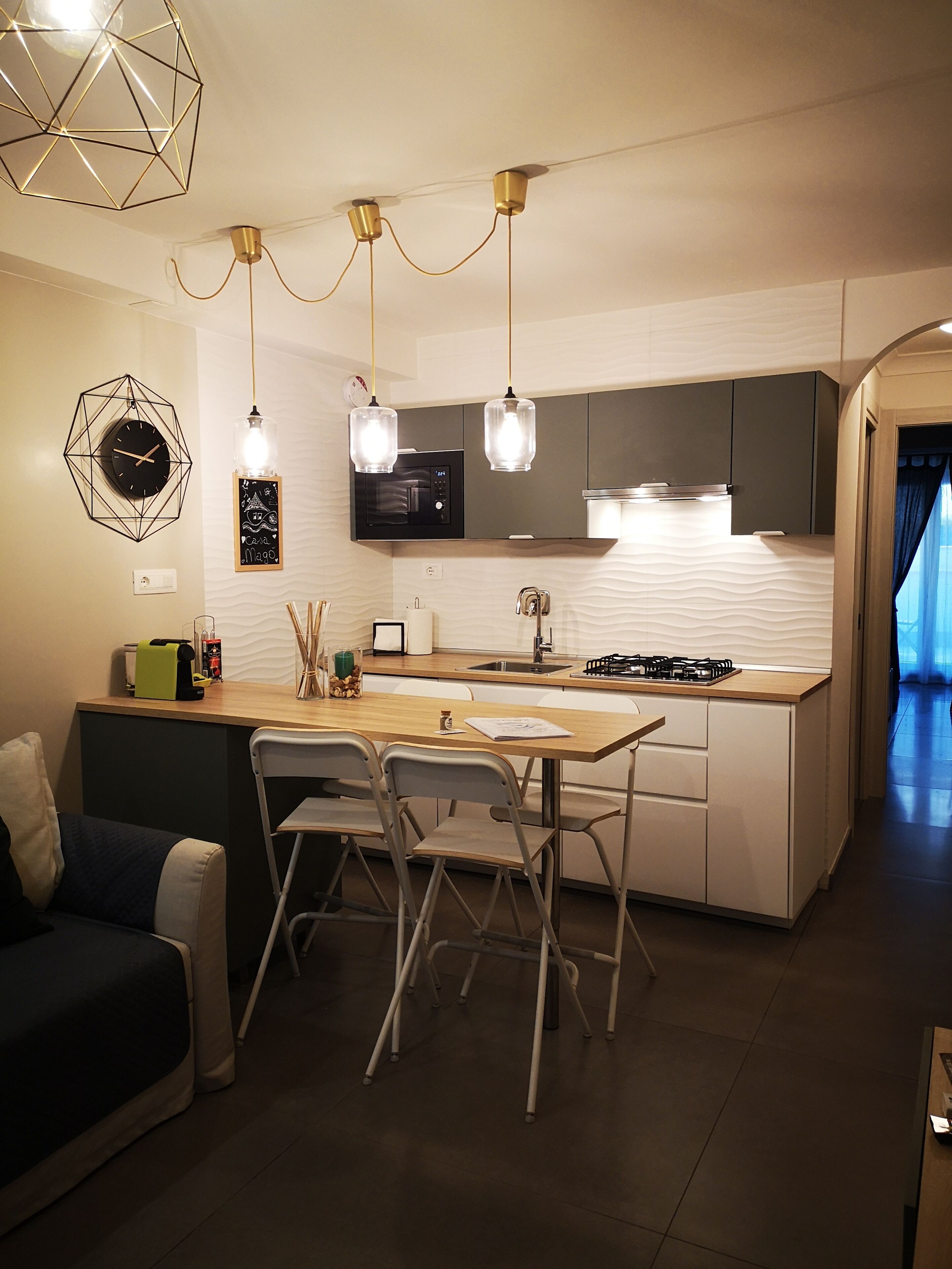 Une cuisine moderne dotée d’un îlot central, d’un coin repas avec des chaises et d’un four à micro-ondes encastré.