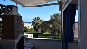 Ein Balkon mit Steinofen, Meerblick und einem Gebäude im Hintergrund.