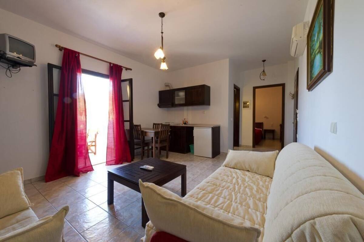 A compact living space with a sofa, a dining table, and a kitchenette.