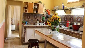 A kitchen with a central island, a wooden cabinet, and a hanging light fixture. - Hostal La Casa Roja TRINIDAD (Trinidad)