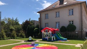 Ein Hotel mit Spielbereich, inklusive Rutsche und einem kleinen Haus.