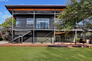 A two-story building with a balcony, a staircase, and a grill area.