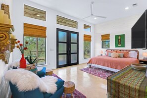 Une chambre spacieuse avec un grand lit, un coin salon avec un canapé bleu et un coin repas avec une table et des chaises.
