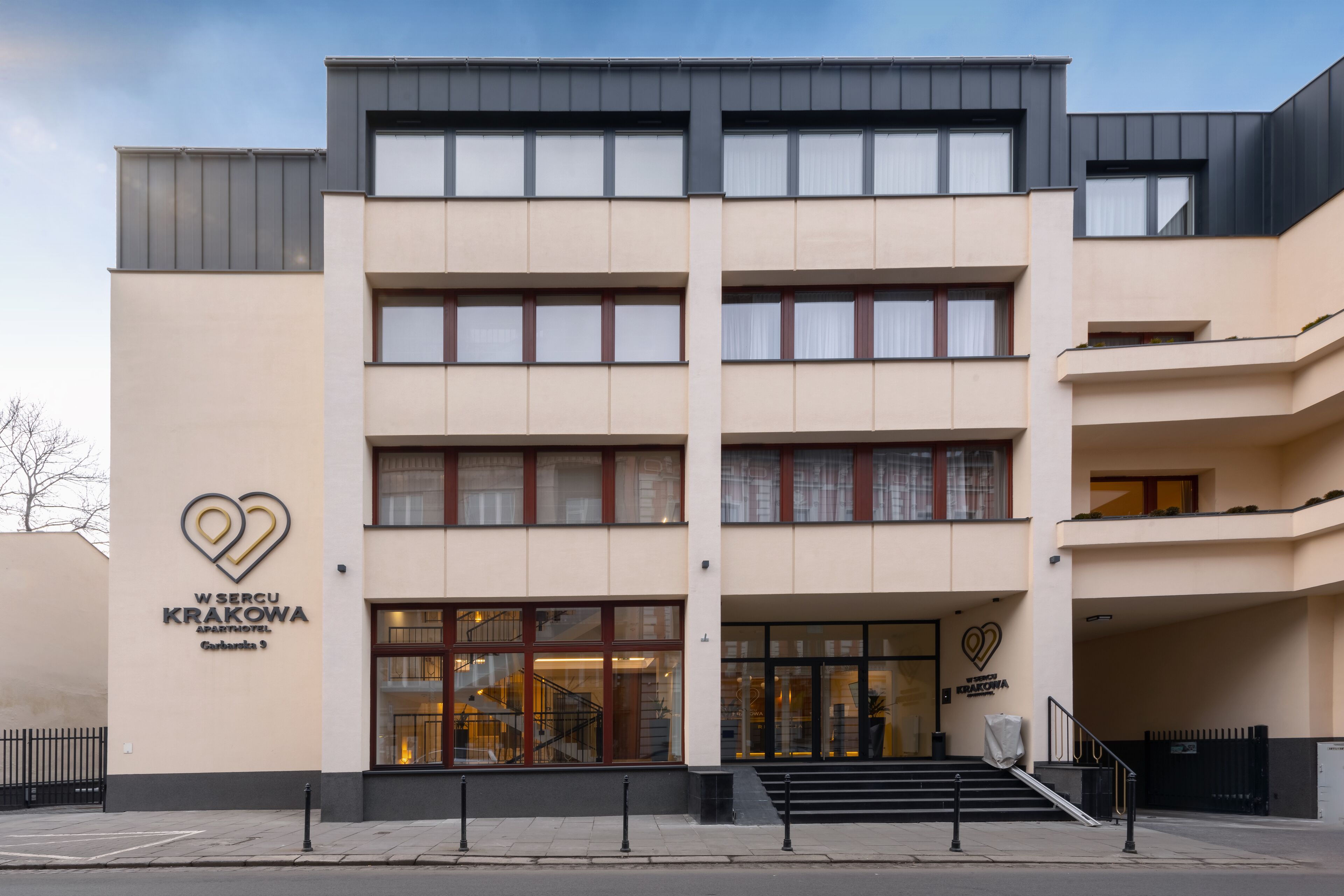A multi-story hotel with a modern design, featuring a prominent heart-shaped logo on the facade.