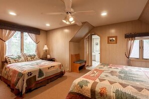 A bedroom with two beds, a ceiling fan, and a view of the outside. - Walk to Lake | Hot Tub, Game Room, Large Backyard & Peekaboo Lake Views (Big Bear Lake)