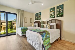 Una camera d'albergo con due letti, un'ampia finestra vista all'esterno e opere d'arte alle pareti.