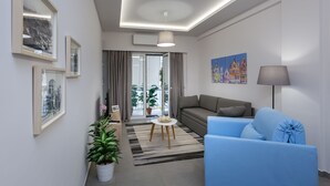 A modern living room with a sofa, a blue armchair, a small table, and a lamp. There are framed pictures on the wall and a potted plant. - 57m² Koukaki Luxury Flat next to Acropolis & Metro (Athens)