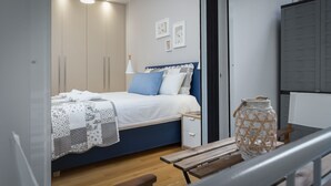 A bedroom with a bed, bedside table, and a nightstand. - 57m² Koukaki Luxury Flat next to Acropolis & Metro (Athens)