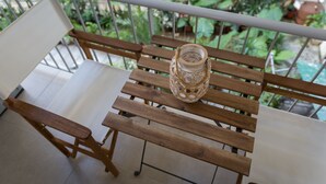 A wooden bench with a glass bottle on it, surrounded by greenery. - 57m² Koukaki Luxury Flat next to Acropolis & Metro (Athens)