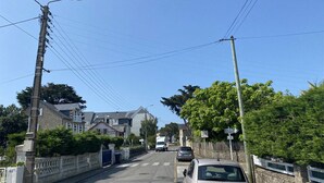 A residential street with houses, a car, and utility poles. - 350m from the beach - flat for 4 (Pornichet)
