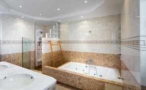A bathroom with a bathtub, a shower, and a sink. - 290m² Villa with Pool close to the Airport (Vari-Voula-Vouliagmeni)