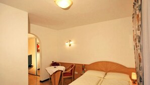 Quarto de hotel com uma cama, uma escrivaninha e uma cadeira.