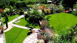 Um jardim bem cuidado com gramado, caminhos e diversas plantas.
