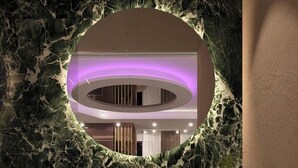 A marble staircase with a circular mirror and a purple-lit interior. - Giafra Rooms (Agrigento)