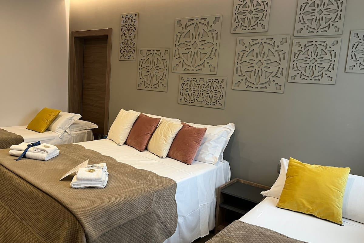 Kamar Quadruple Deluks (106) | Seprai premium, busa memori, minibar, dan brankas