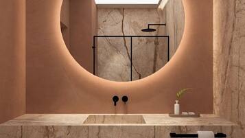 A modern bathroom with a round mirror, a sink, and a towel rack.
