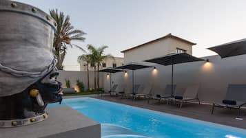 Piscine extérieure, parasols de plage, chaises longues