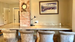 A kitchen with a marble countertop, a brick pillar, and a framed landscape painting. - Ruby`s House ~ Downtown Durango (Durango)