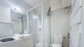 Een moderne badkamer met een glazen douchecabine, een wit toilet en een wastafel met spiegel.