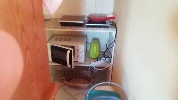 Eine Küche mit Mikrowelle, Toaster und einer roten Bratpfanne auf der Arbeitsfläche.